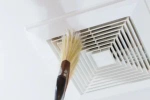 Broom cleaning ceiling vent