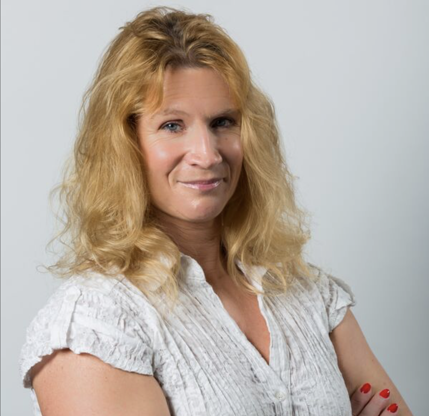 Photograph of Angie, blond hair female with white shirt arms folded